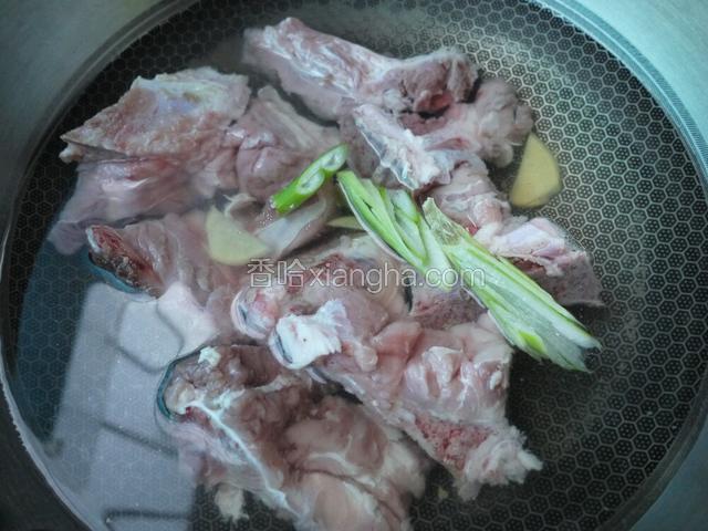 坐锅加凉水加葱姜、料酒，焯猪脊骨，焯好后温水冲洗干净。