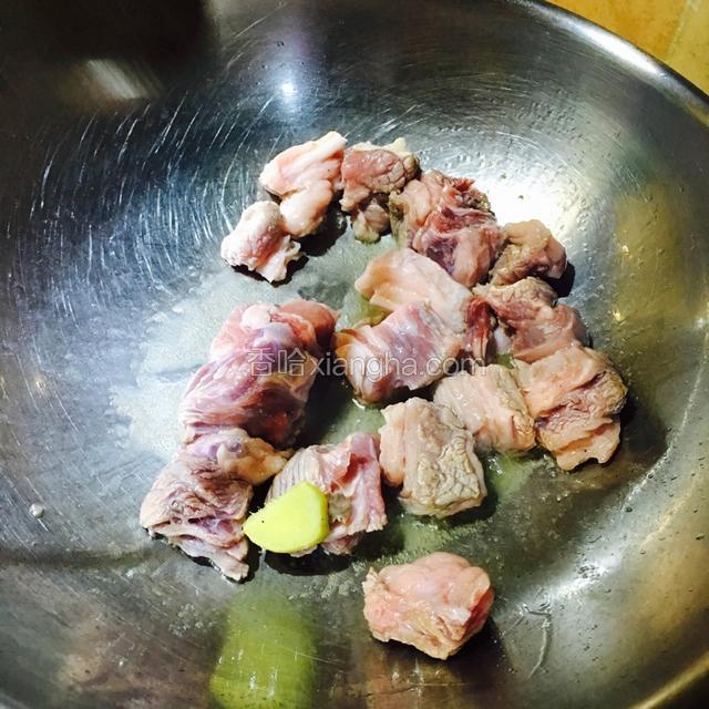 切一片姜，热锅热油，用姜片滑锅后，倒入牛肉块翻炒片刻，期间加入料酒。