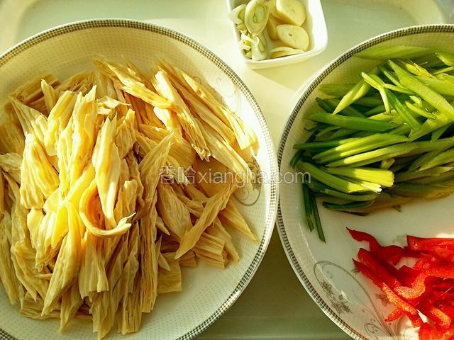 腐竹洗净切斜段；芹菜切斜段、红椒切成条；葱蒜切下图样