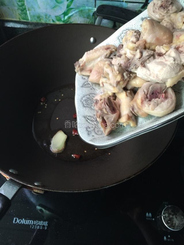 倒入适量油烧热，先把生姜和干辣椒放入，再放鸡肉翻炒一会。