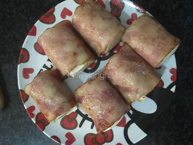 用培根把豆腐卷起来，淀粉用水调成糊状封口
锅内倒入适量油，把培根豆腐卷煎至微黄