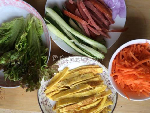 黄瓜，胡萝卜，火腿切丝，鸡蛋用平底锅煎成饼切条，生菜撕成小片备用