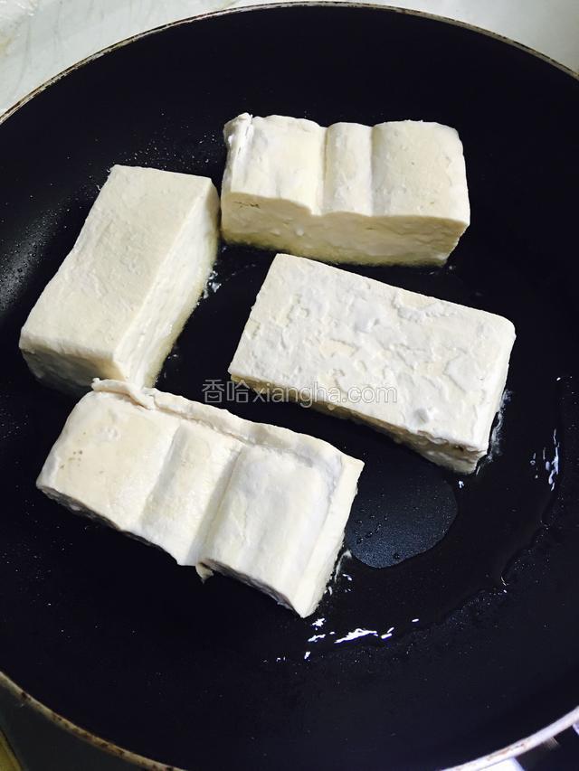 把豆腐反扣入锅中，小火慢慢煎炸
