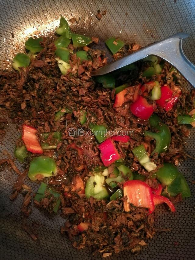 锅里再倒入一些食物油，等油烧开了，把两种辣椒丢进去，用大火爆炒出香味，一两分钟以后再把梅干菜丢进去一起炒。