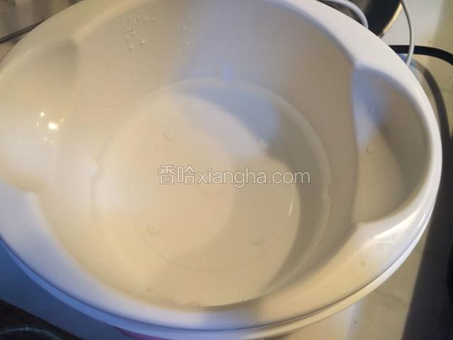 酸奶机插上电，往酸奶机内倒入少许热水。