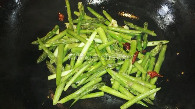 倒入切好的芦笋，翻炒片刻，加少许生抽，盐和黑胡椒调味。