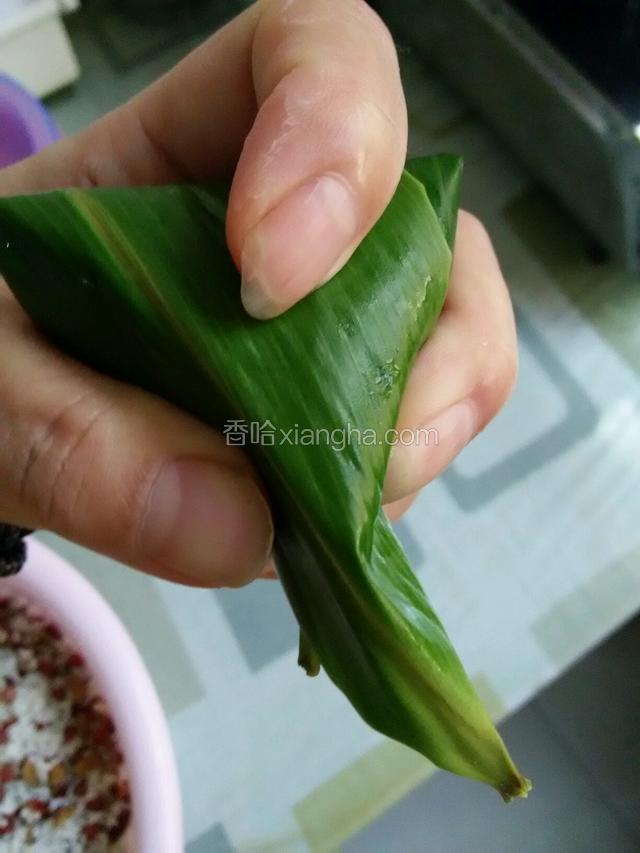 把伸出的叶子压过来，用手指捏成三角