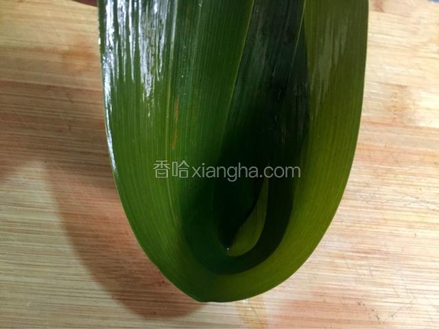 煮透的粽叶过冷水，取两个粽叶头尾相对折成漏斗状
