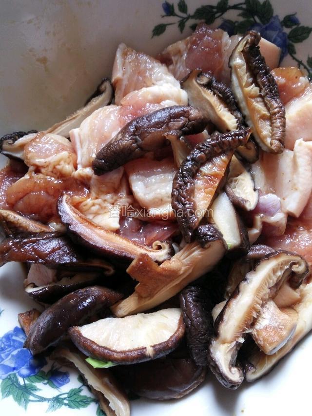 把泡好的香菇放入五花肉里一起入味。