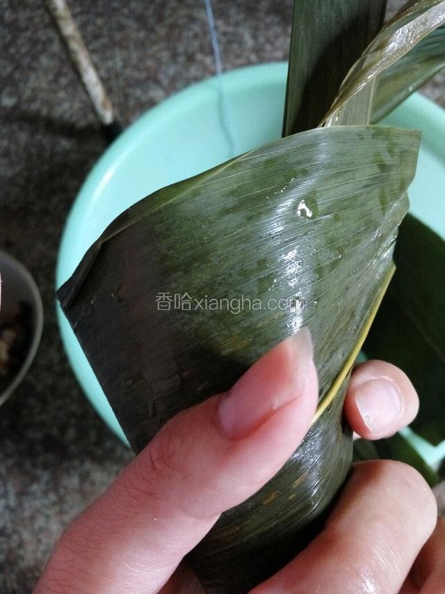 拿上两片粽叶，卷成一个三角形的形状