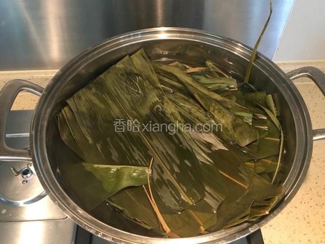 泡好的粽叶清洗干净，减去硬根部，和马莲草一起在锅里煮10分钟。备用。