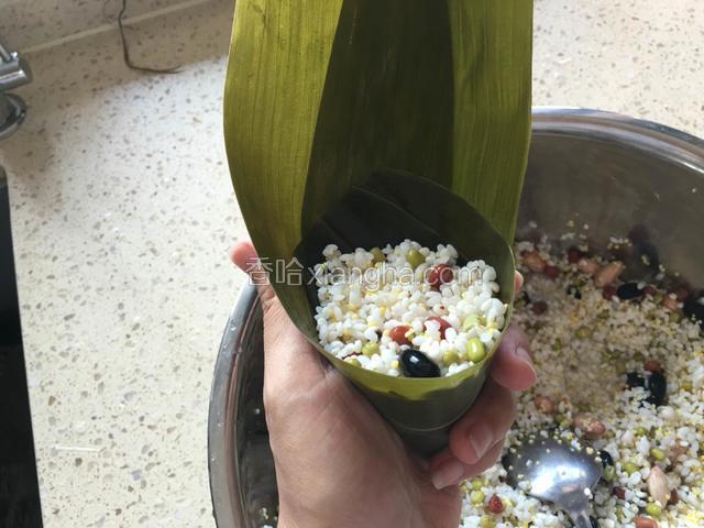 用勺子装入适量的米，用勺子压实。