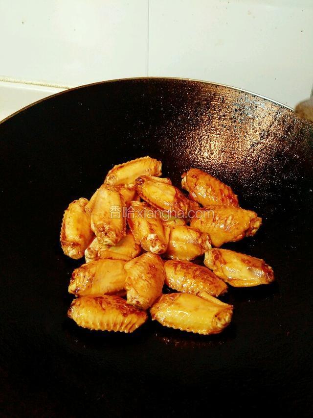 把鸡翅倒入锅，两面煎成金黄色。