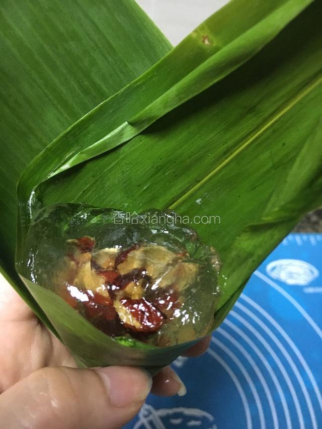 粽叶洗干净，稍煮片刻，包上红枣整型像三角形然后放入已经折像漏斗型的棕叶里