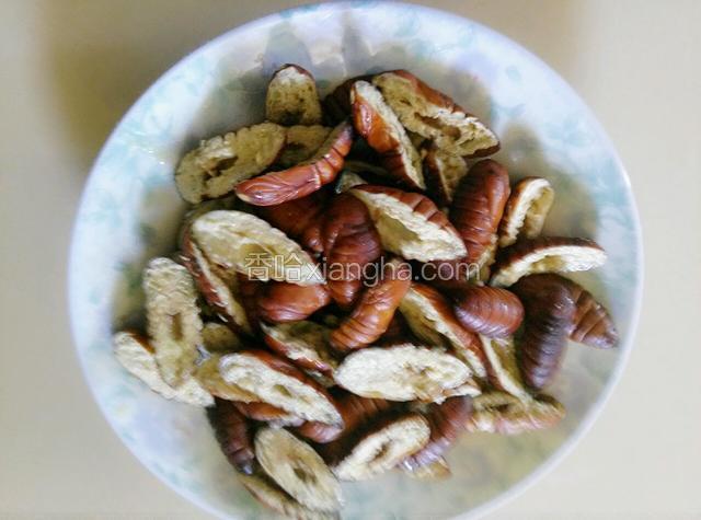 茧蛹蒸好了，用剪子把茧蛹竖着从中间剪开，把黑的去掉