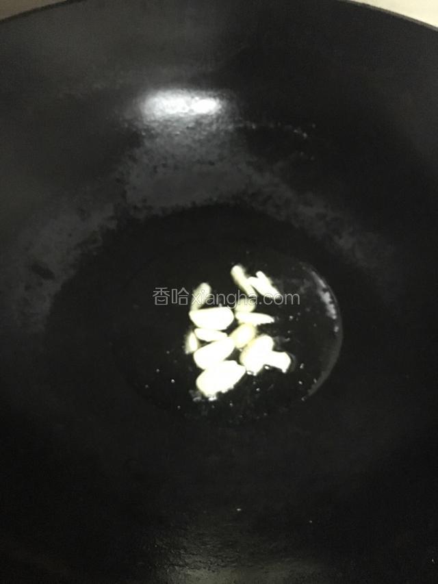 大火烧热锅倒入适量的花生油烧热放入蒜头片稍爆
