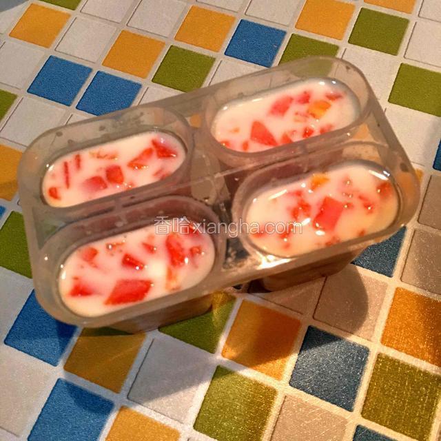 将搅拌好的木瓜酸奶用小勺子加入模具中