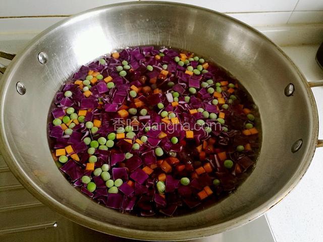 倒入紫甘蓝，豌豆和胡萝卜焯水至断生。
