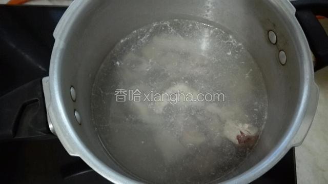 取一压力煲将水煮沸把排骨先去掉血水。