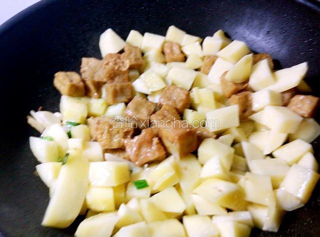 爆炒一会土豆块，再下豆腐泡，继续爆炒着，豆腐泡还没化冻呢，