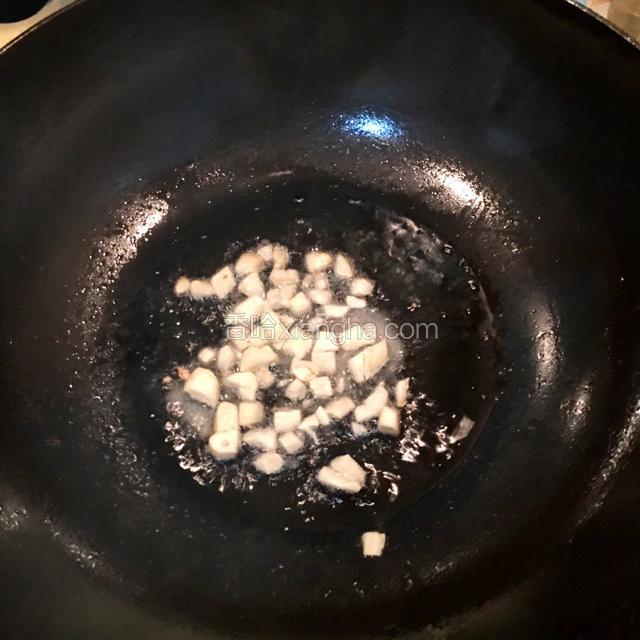 热锅下油，油温七成热下入大蒜子爆香