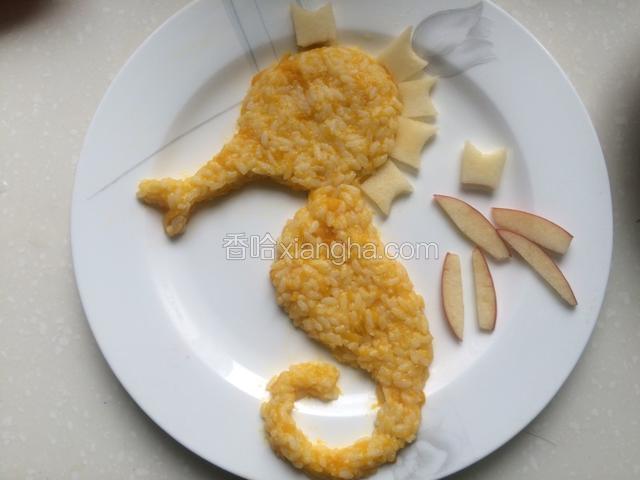 取适量南瓜米饭从海马头部开始一点点往下压成全部海马形状，
切一片和海马身体相同厚度的苹果，
然后分开切成6个异形小块放到头部
再切几条带皮的苹果条，厚度稍扁一点，放到缝隙中