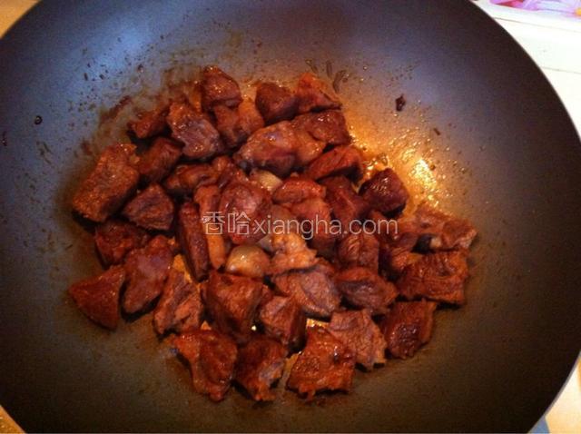 将牛肉倒入炒好糖色的锅里翻炒，牛肉均匀的上色
