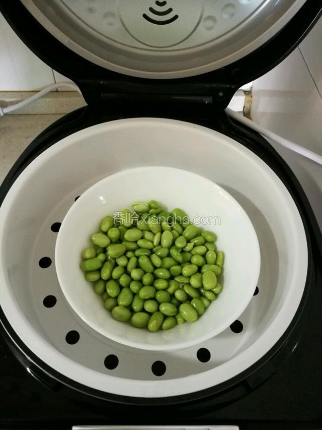 将毛豆去皮，把豆子剥出来，放入清水中搓洗干净，拿来隔水蒸20分钟左右，我是煮饭的时候隔水真的，这样省事 。
(我个人不太喜欢拿来炒，太多油了，豆子也不那么容易熟，炒出来也没那么营养了)