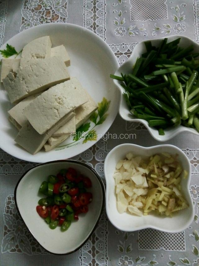 豆腐洗净改刀长方形小块，韭菜洗净切段，姜和蒜坨切末，青红椒切圈。