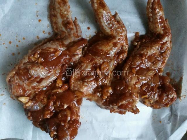 烤盘放油纸，摆好鸡翅，刷点油在上面
烤箱设置上下管温度200，时间30分钟
预热好放进烤箱
十五分钟时取出来翻面，再刷油，将剩余的料汁淋在上面