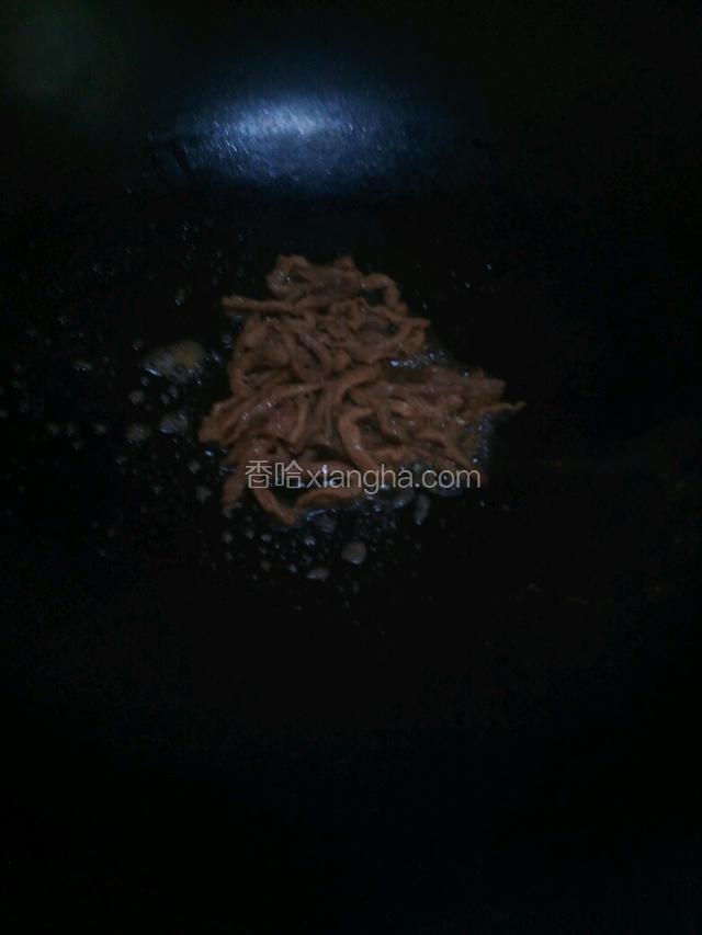 锅里把油烧热，小火放入腌制的鸭肉丝翻炒至变色
