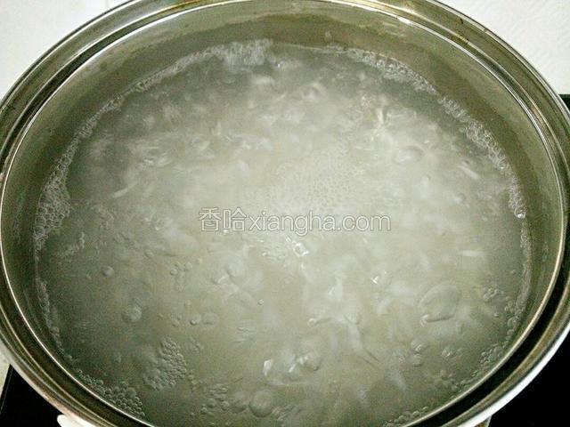 锅里水烧开，倒入糯米煮开花。
