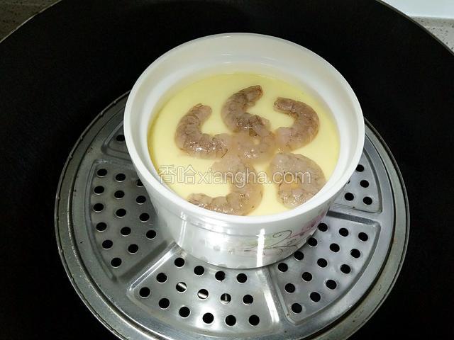 时间到鸡蛋羹也定型了，再把虾仁摆好放入鸡蛋羹里，盖好盖子约五分钟就可以。