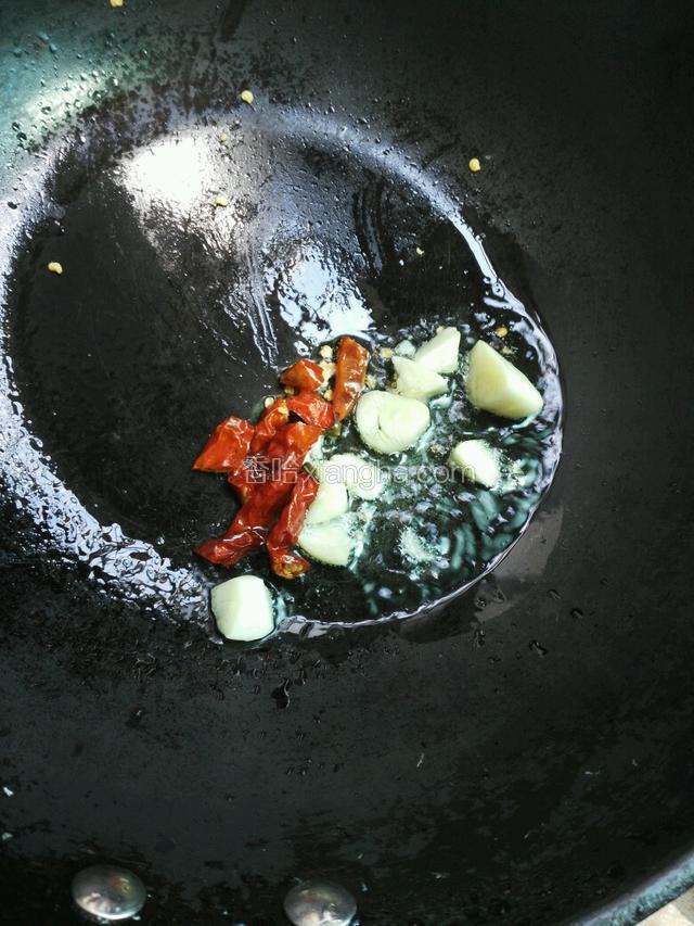 锅里热油，爆香大蒜、干辣椒