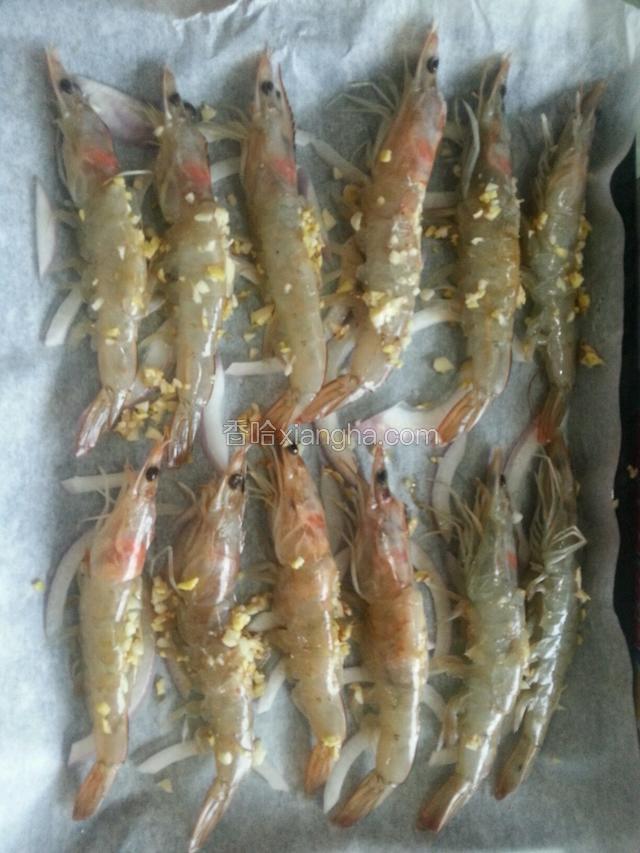 烤盘上放油纸，铺上洋葱，把调味料涂在虾上，200度烤30分钟