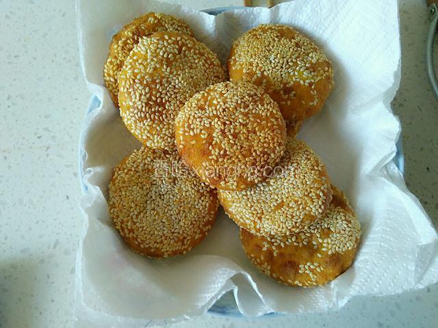 炸好的南瓜豆沙芝麻饼在吸油纸上控油