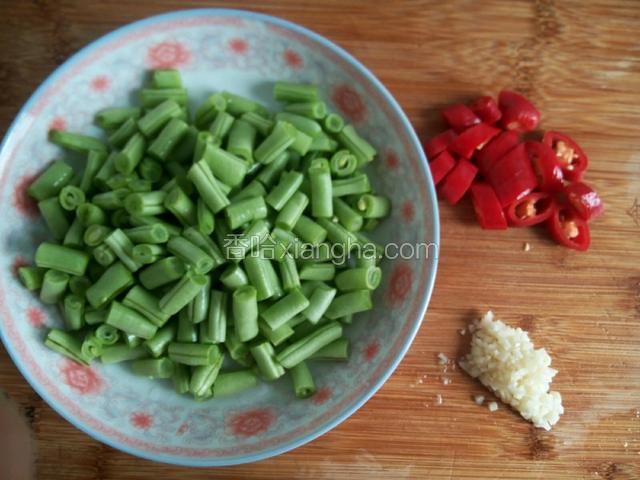 四季豆切去两头，洗净后切成1厘米丁，红辣椒切圈，蒜切沫