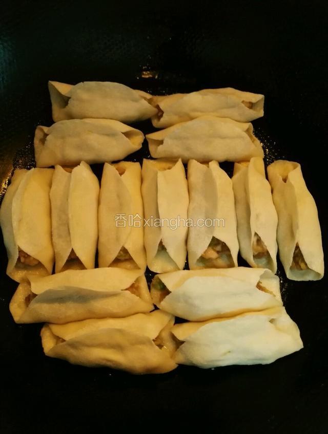 全部完成后平底锅淋少许油把锅贴码放在锅里，小火直至底部微黄