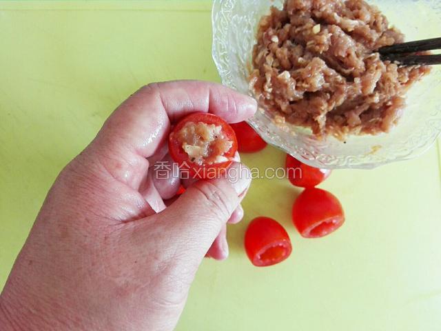 用筷子夹少许鸡肉泥，填满圣女果中。