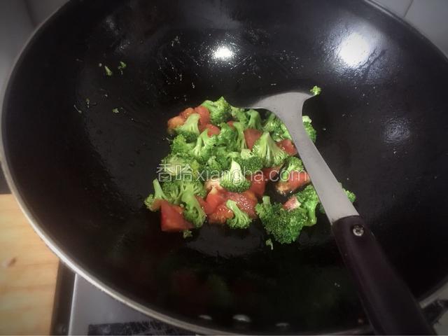 锅里热油，放入生姜碎，西兰花和备用的番茄，一起翻炒，并加入白糖，蚝油和盐