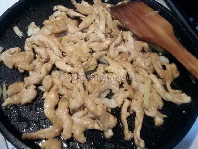 倒入腌制好的鸡丝划散，炒至变色；
