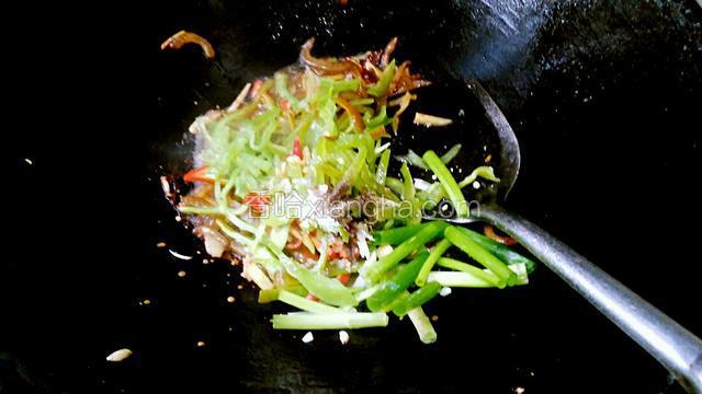 加入青椒红辣椒葱段，胡椒粉，盐，味精再把卤肉皮的卤水加十克炒匀。