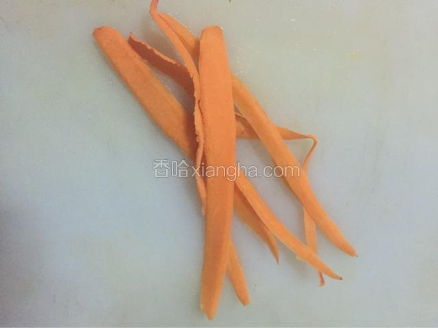 胡萝卜去皮用削皮刀削8条胡萝卜条备用