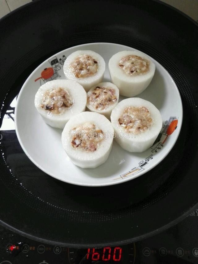 锅里放适量水，用一个蒸菜的小架子把酿好的白萝卜放上面。
