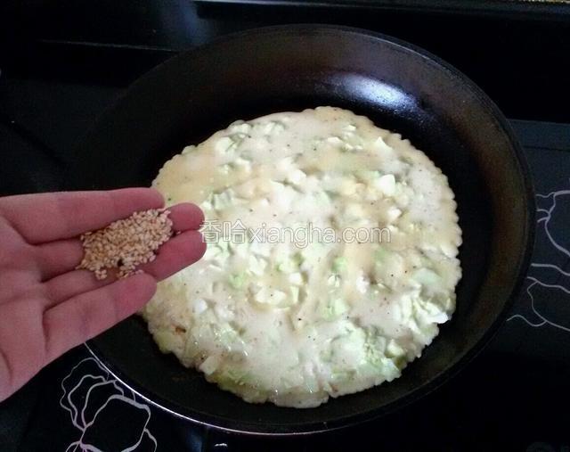 在饼上面撒一些芝麻。