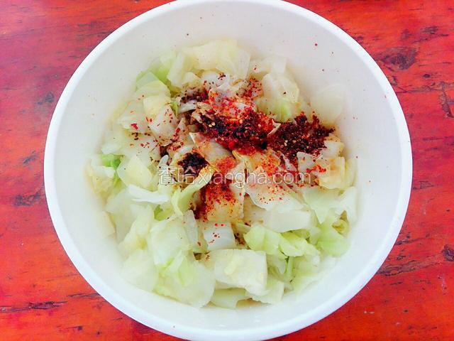 控干卷心菜的水分，给里边加入盐，辣椒面，鸡精，醋，味极鲜，锅里倒油，油温升高后把油泼到辣椒面上，搅拌均匀后，即可盛入盘子里食用。