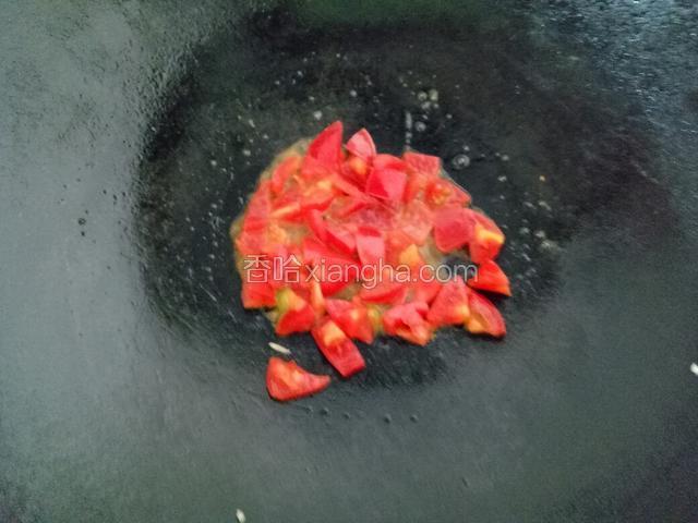 锅内加油，炒圣女果至半熟。