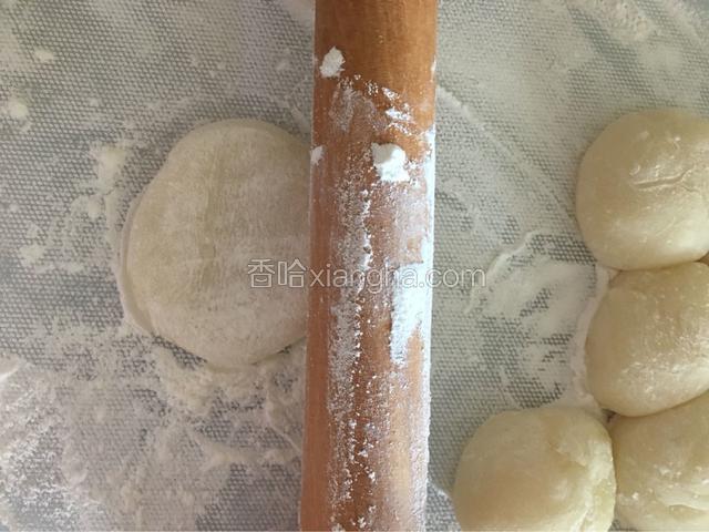 用擀面杖把小粉团擀成饺子皮那样的面皮