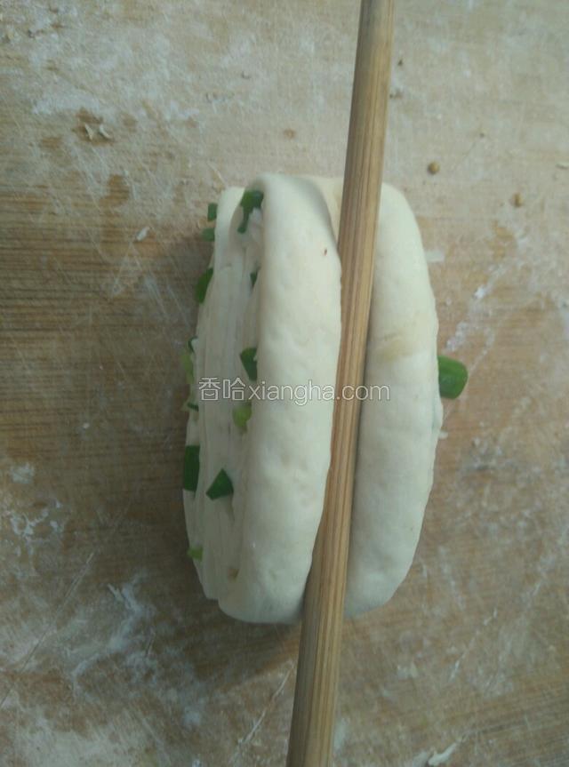 取两块面团叠一起，中间用筷子压下，两头捏住往相反方向拧。