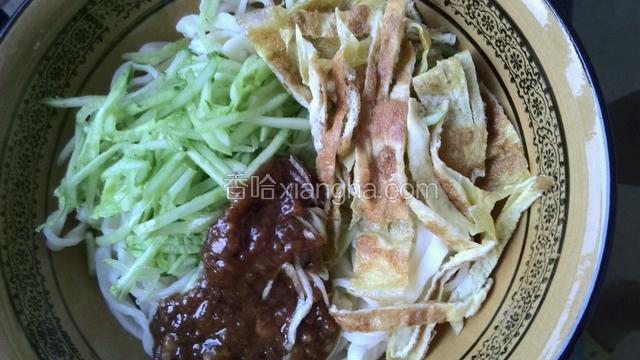 面装大碗，放入黄瓜丝、炸酱、鸡蛋饼丝、蒜泥搅拌均匀。